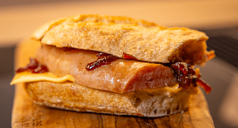 Broodje rookworst met cheddar en gekaramelliseerde ui